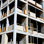 **

A construction site featuring workers installing innovative insulation materials on a high-rise building. The image should emphasize the sleek design and advanced technology of the materials, conveying a sense of modernity and energy efficiency. Focus on the exterior of the building, highlighting the insulation's impact on the building's overall aesthetic. Consider a sunny day with a clear blue sky to showcase the building's visual appeal.

**